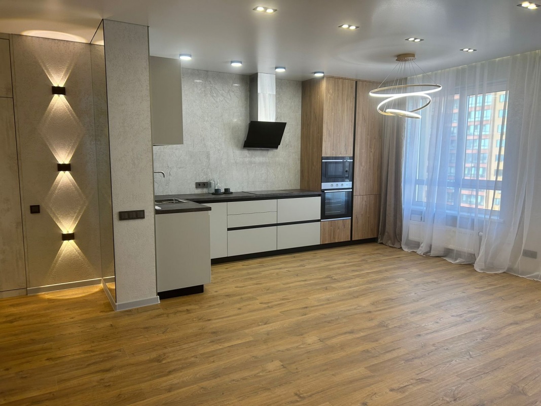 Светлая угловая кухня-гостиная в современном стиле