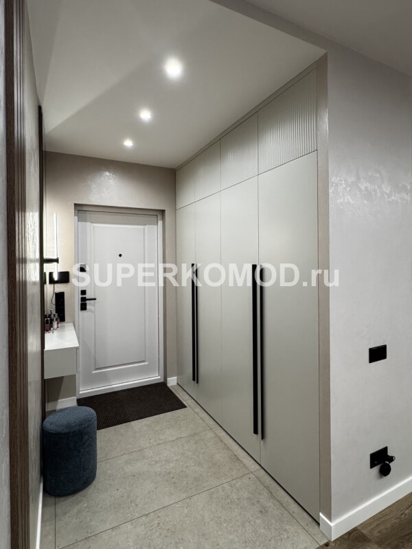 Светлая прихожая с вместительным шкафом и подвесной тумбой с зеркалом